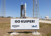 Atlas V rocket on launch pad with "Go Kuiper" sign in foreground