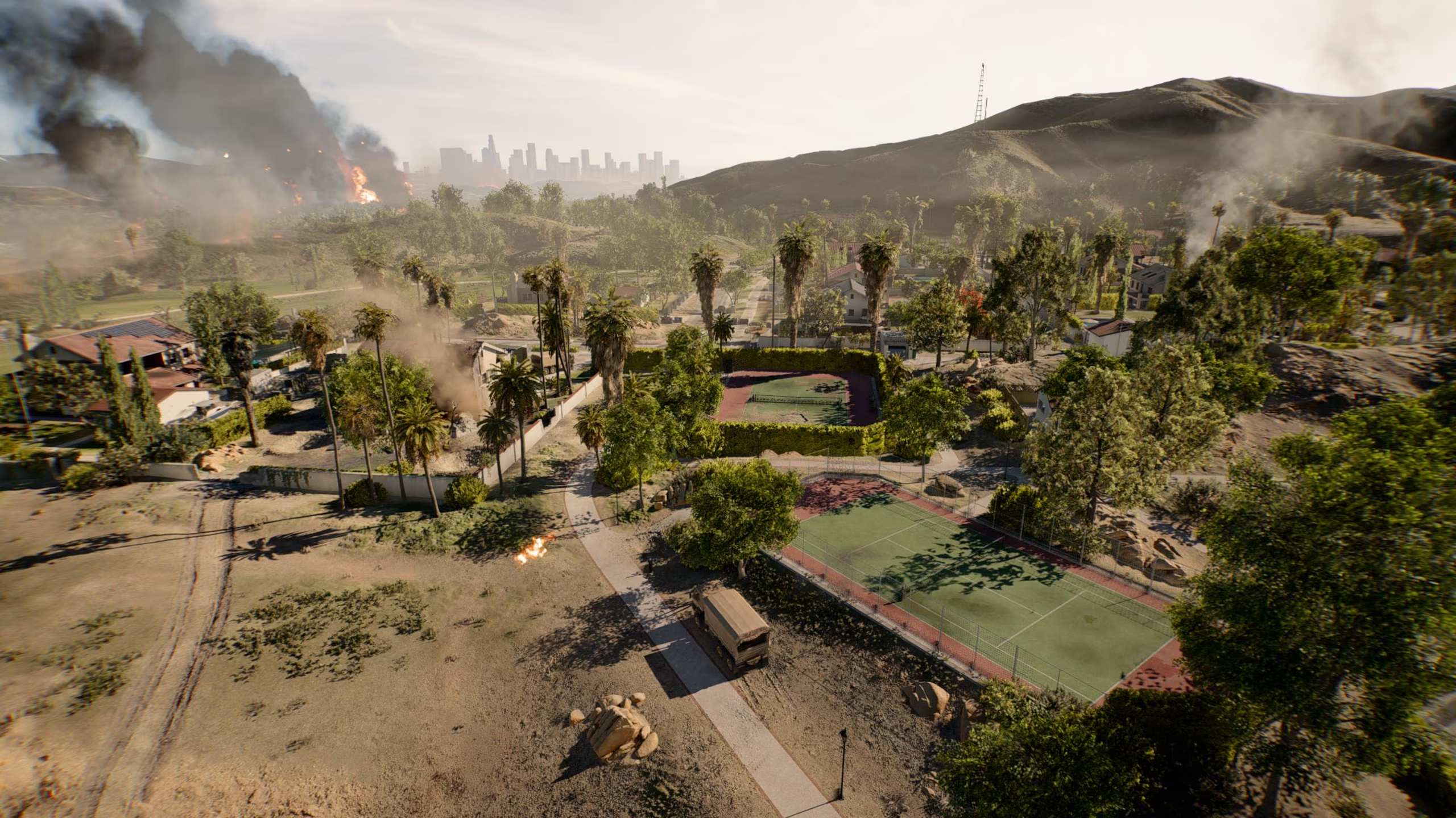 Battlefield 6: An official image of the Eastwood map, showing a Californian suburb, with two tennis courts near the centre of the image, and explosions in the background.