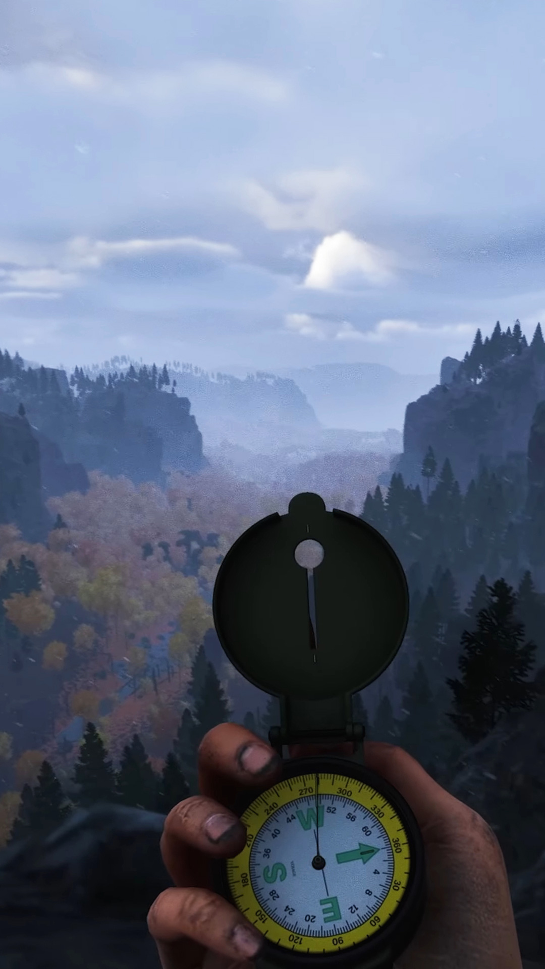 Mountain scenery from Prologue: Go Way back with a player's hand at the bottom holding a compass