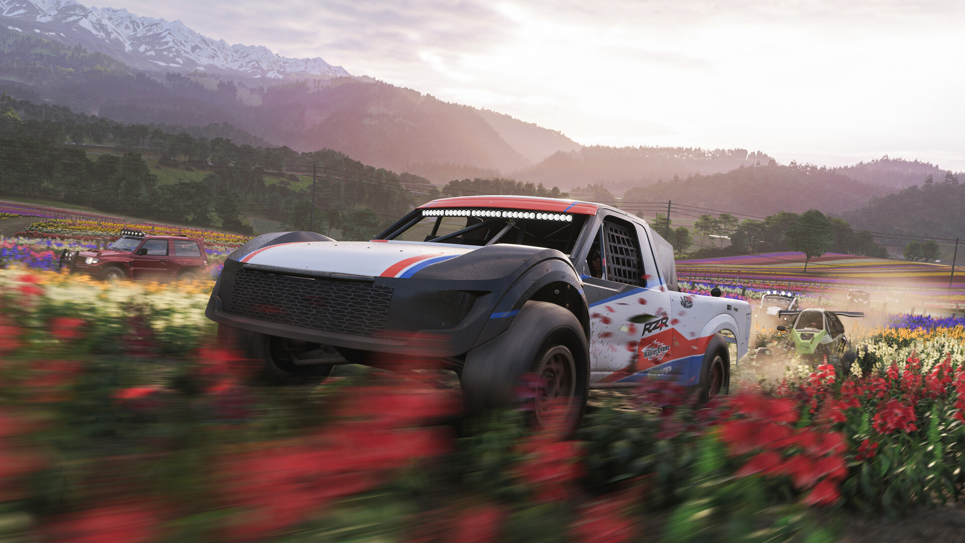 Forza Horizon 6: Several off-road vehicles, including a jeep centre-frame, racing through a field of red flowers.