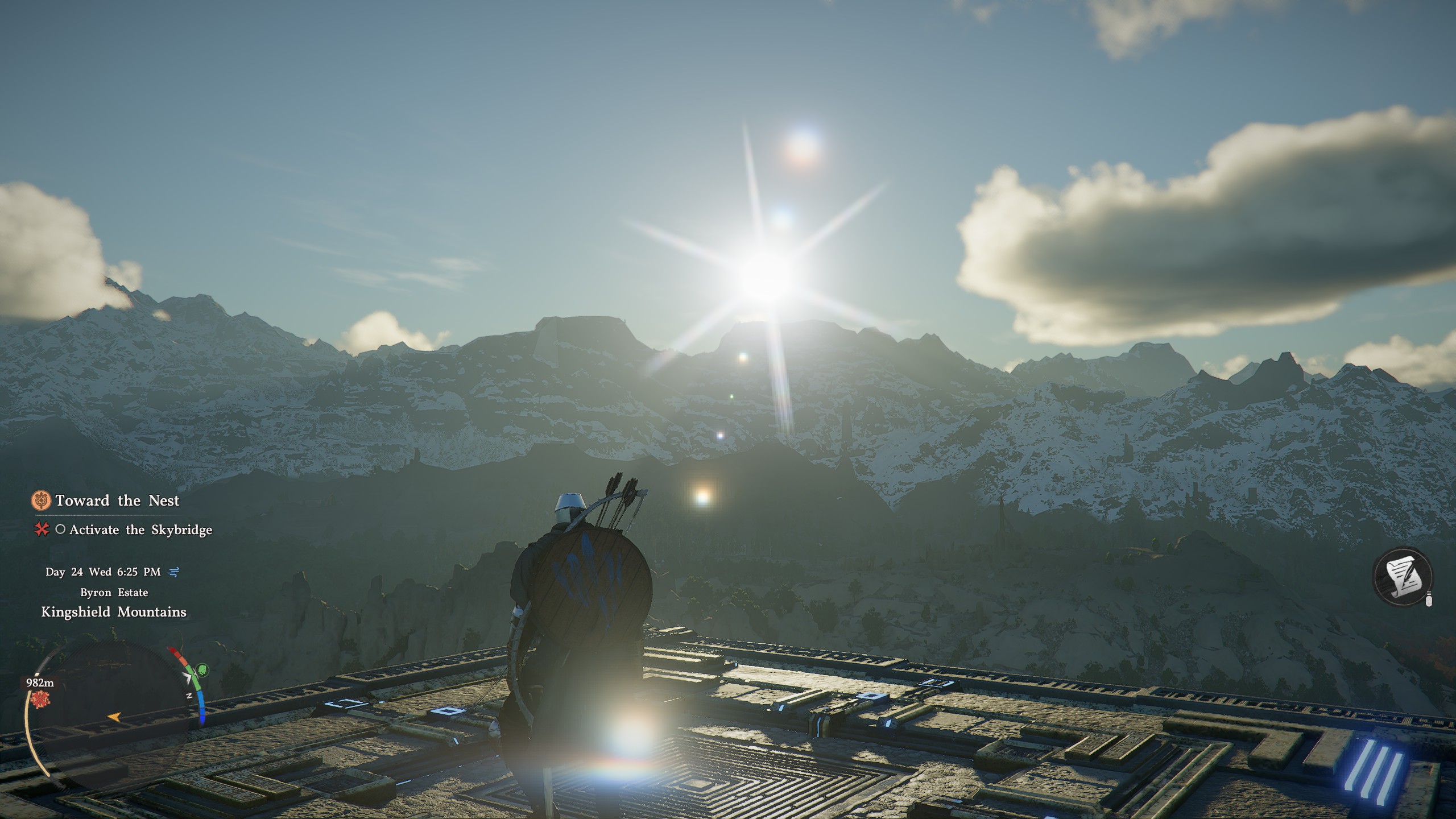 Kliff sits atop a stone cube and looks at snow-capped mountains.