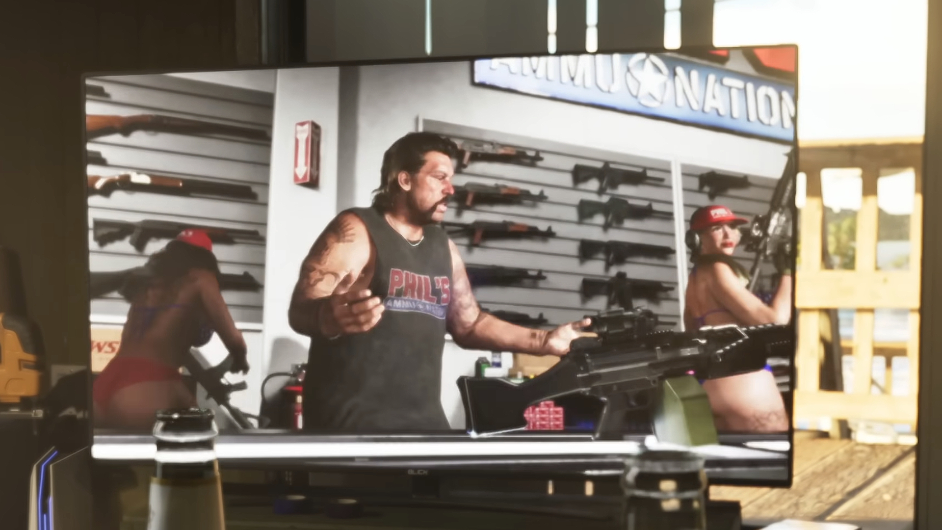 GTA 6 weapons: A gun store owner on TV with a rack of assault rifles on the back wall.