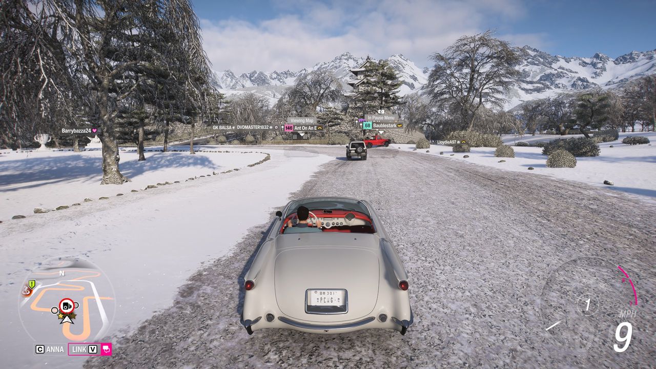 Forza Horizon 6 Hirosaki Castle location: A classic white Chevrolet driving up the path leading to the snow-covered Hirosaki Castle.